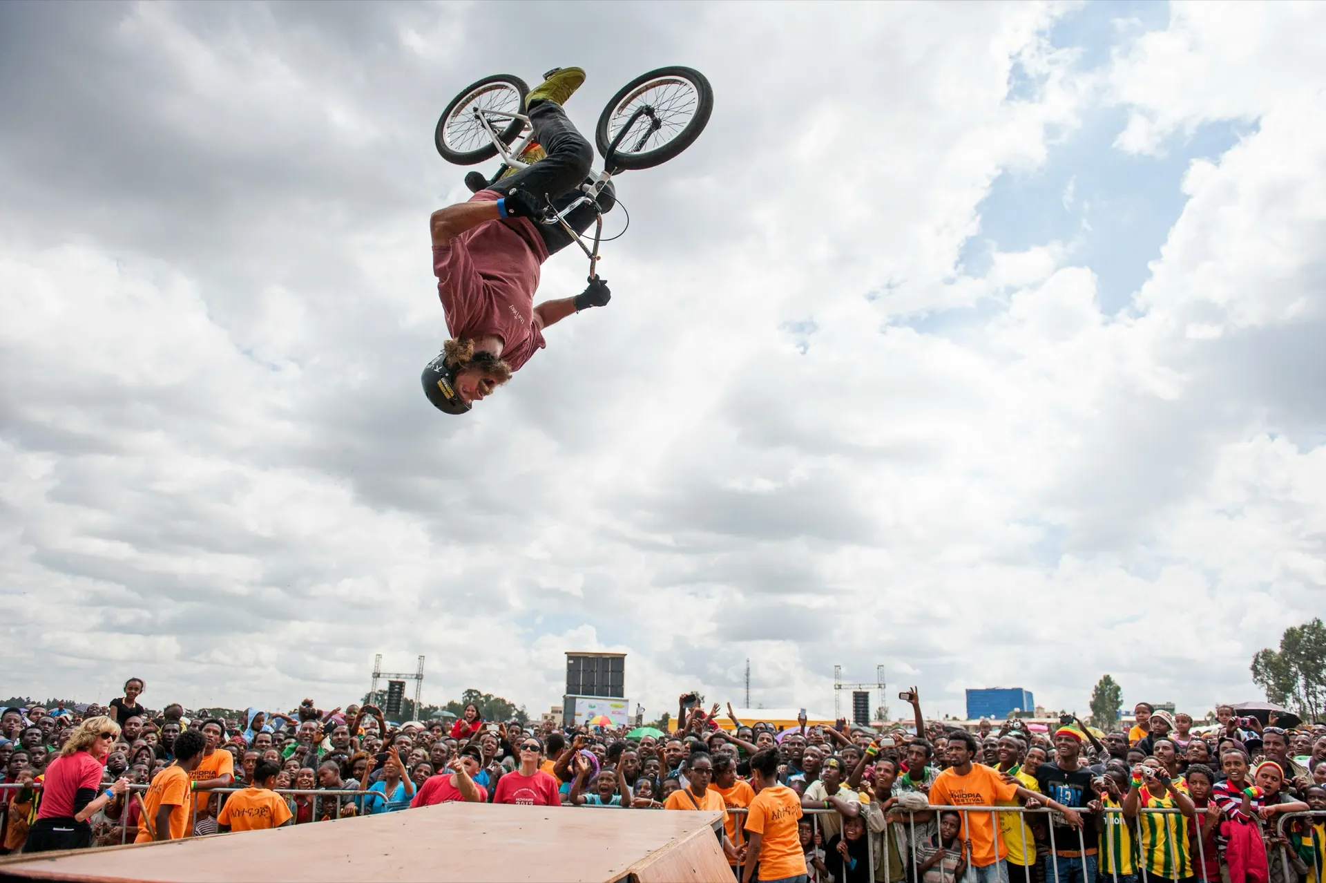 StuntDudes rider mid-backflip high above a huge crowd