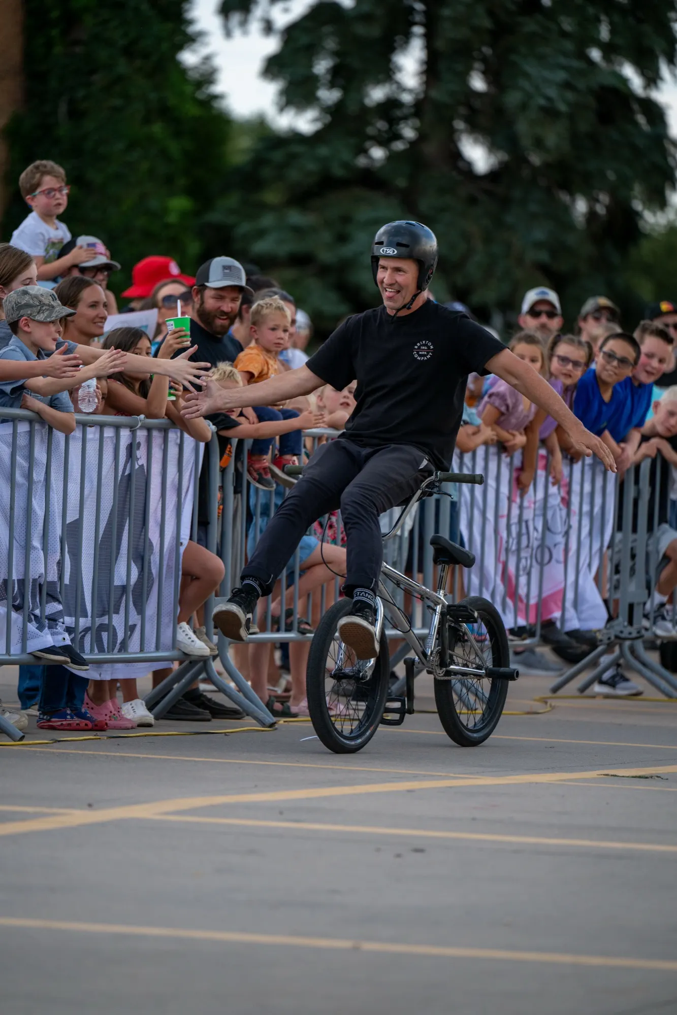 StuntDudes rider high-fiving a line of cheering fans along the barrier